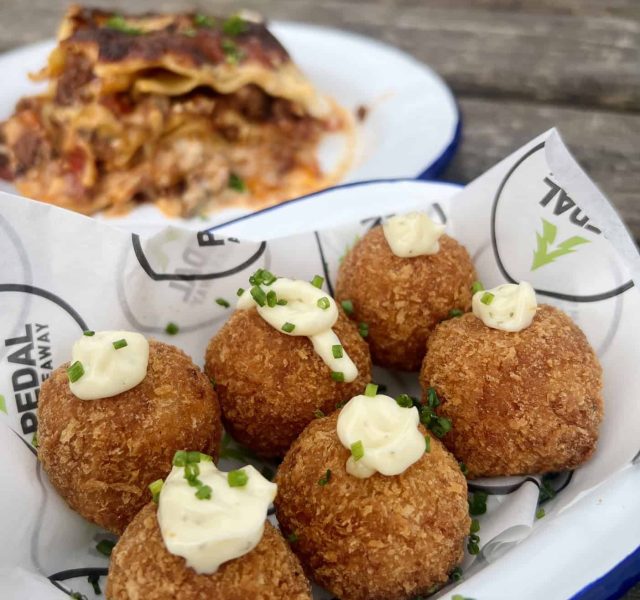 Arancini made fresh in our kitchen with homemade lasagne behind, photo taken in front of our café
